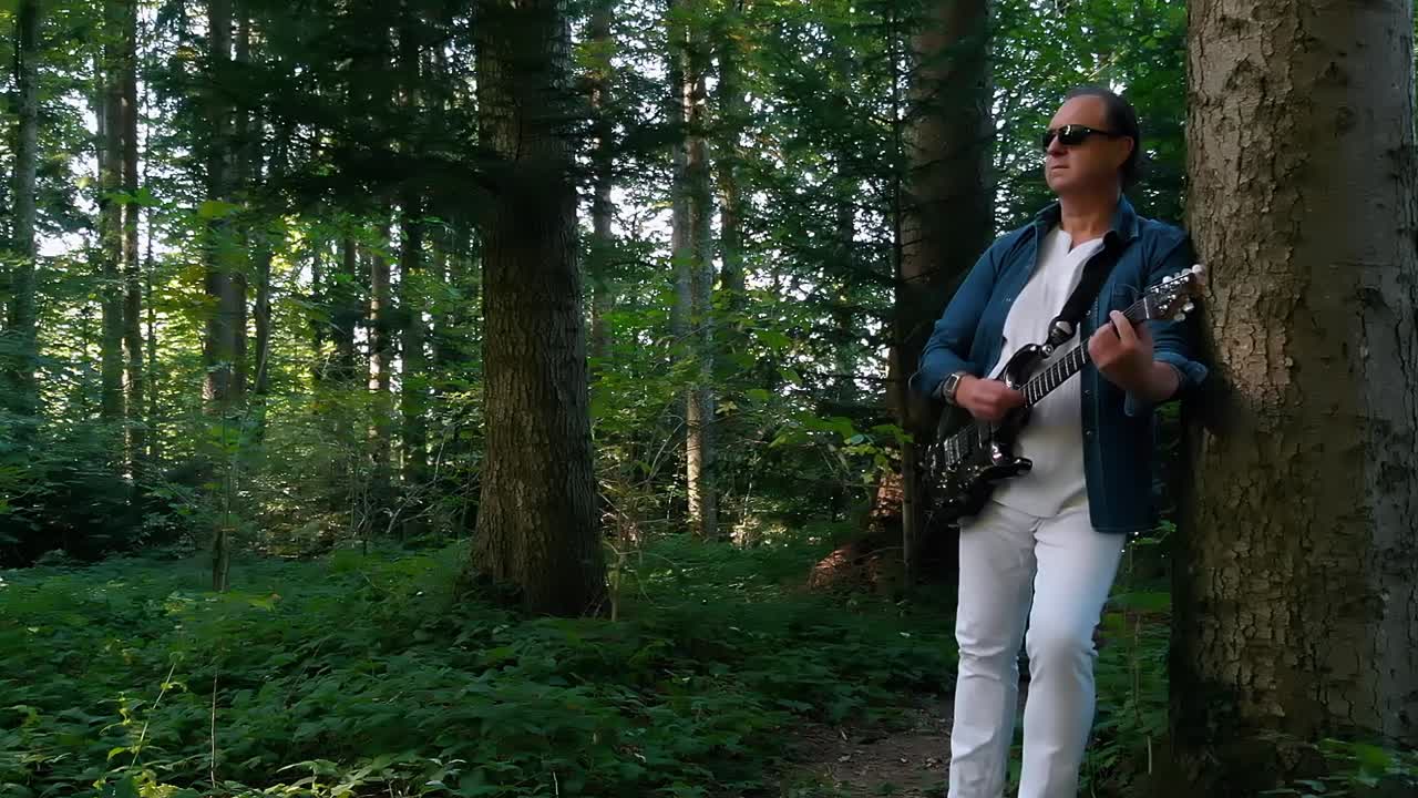 musician Playing guitar in the woods
