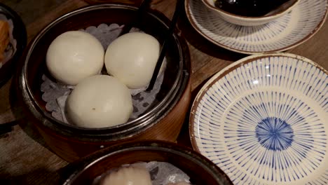 chopsticks serving buns onto a plate