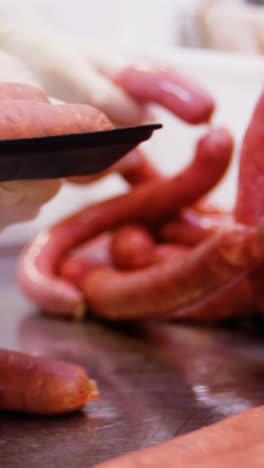 butchers packing sausages in container