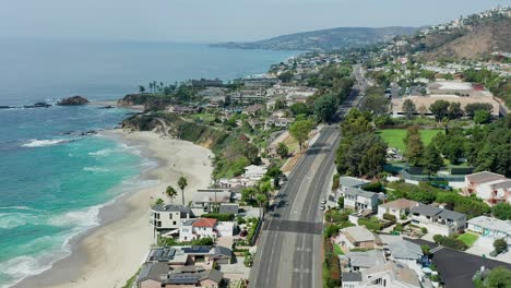 Aerial-view-over-the-Pacific-Coast-Highway-along-the-Laguna-beach-Coastline,-in-Orange-County-California