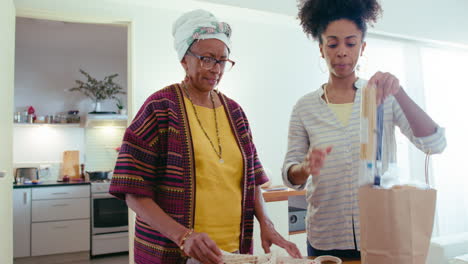 young woman helping senior grandmother with grocery shopping