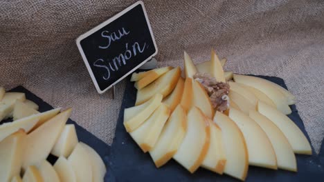 degustation tray of san simon galician cheese with walnuts at outdoor event on black slate