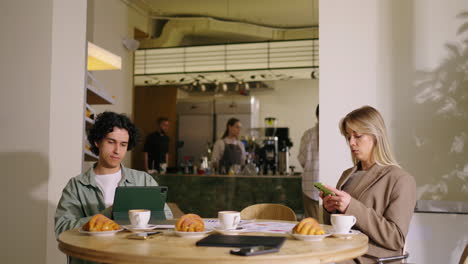 two people working at a cafe table