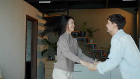 happy couple dancing in modern home kitchen