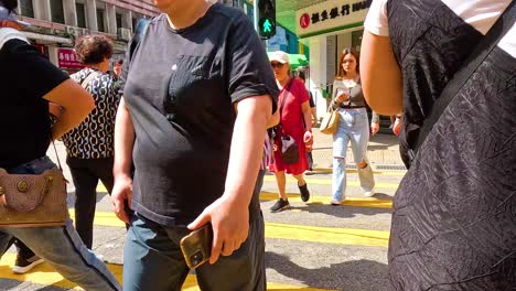 people crossing a bustling street in hong kong