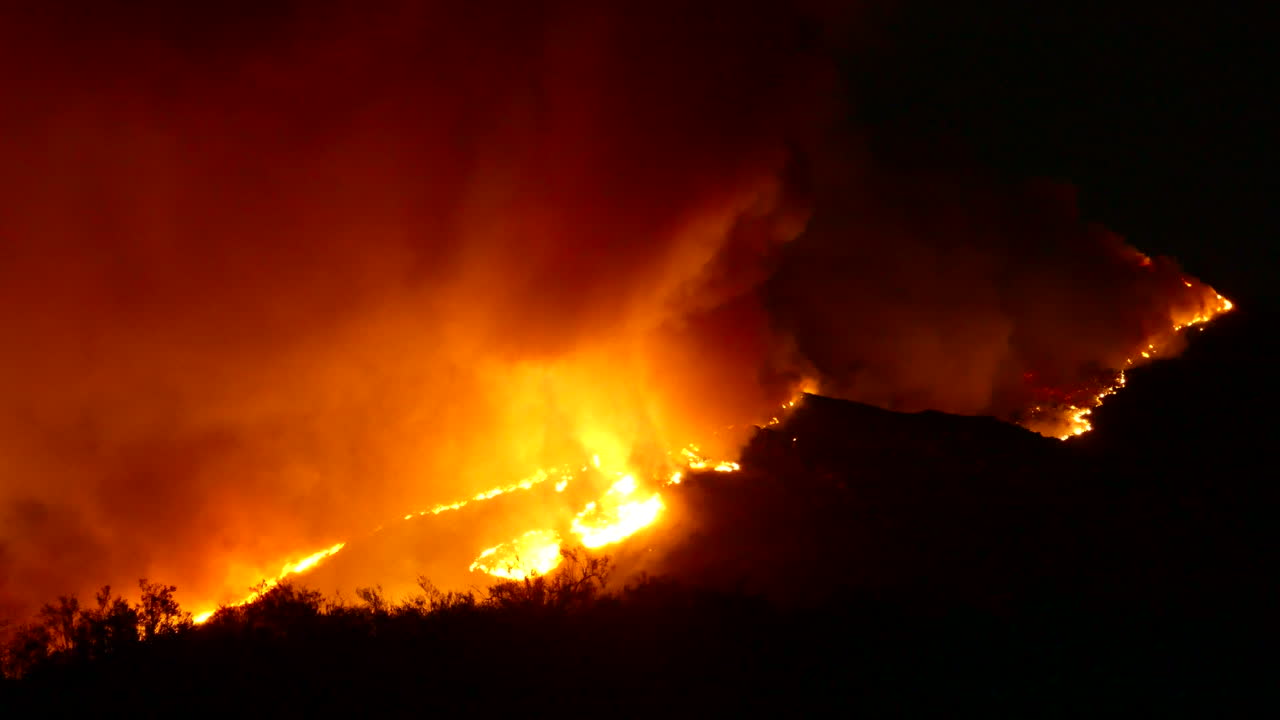 nubes de humo masivas y llamas rojas brillantes de