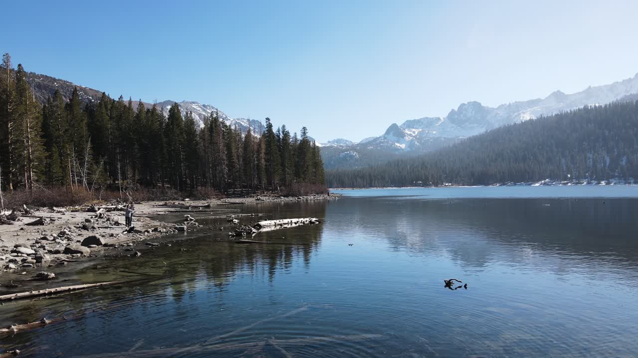 drone retrocediendo cerca del agua en las montañas nevadas en mammoth lakes california