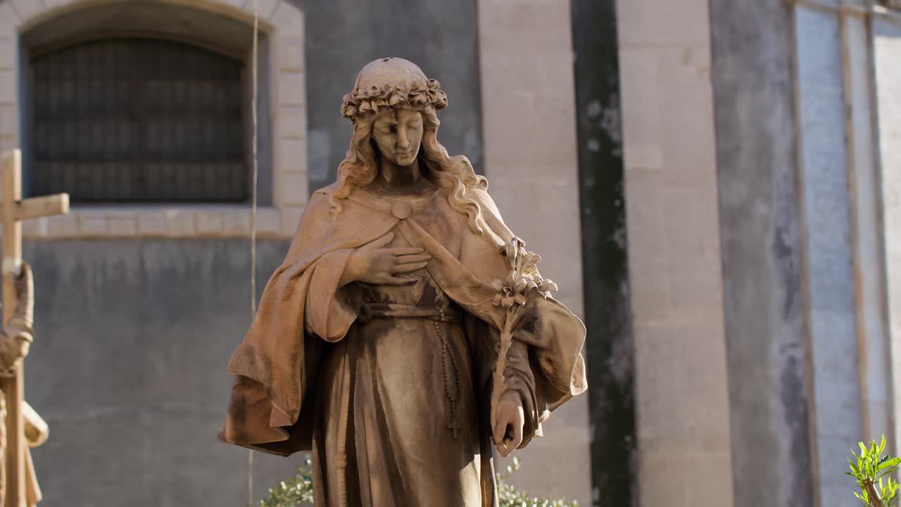 시칠리아의 카타니아에 있는 산타아가타 성당 앞에 있는 동상 위에서 골든 아워를 찍고, 복잡한 세부사항을 포착하고 있습니다.