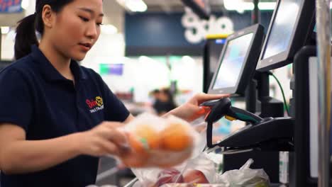 a cashier skillfully places items into bags at a vibrant grocery store. customers are seen waiting in line, showcasing a busy shopping environment and the hustle of everyday life.