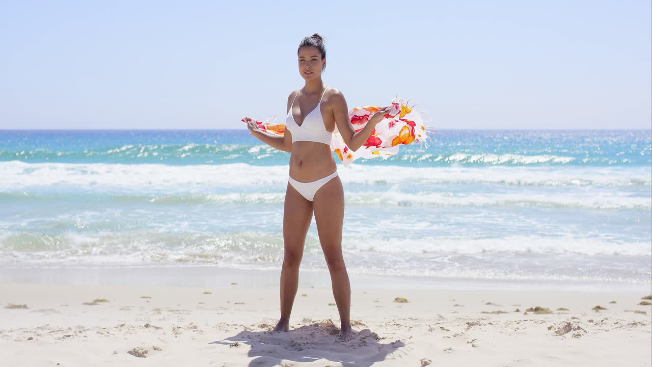 Bella giovane donna in bikini sulla spiaggia
