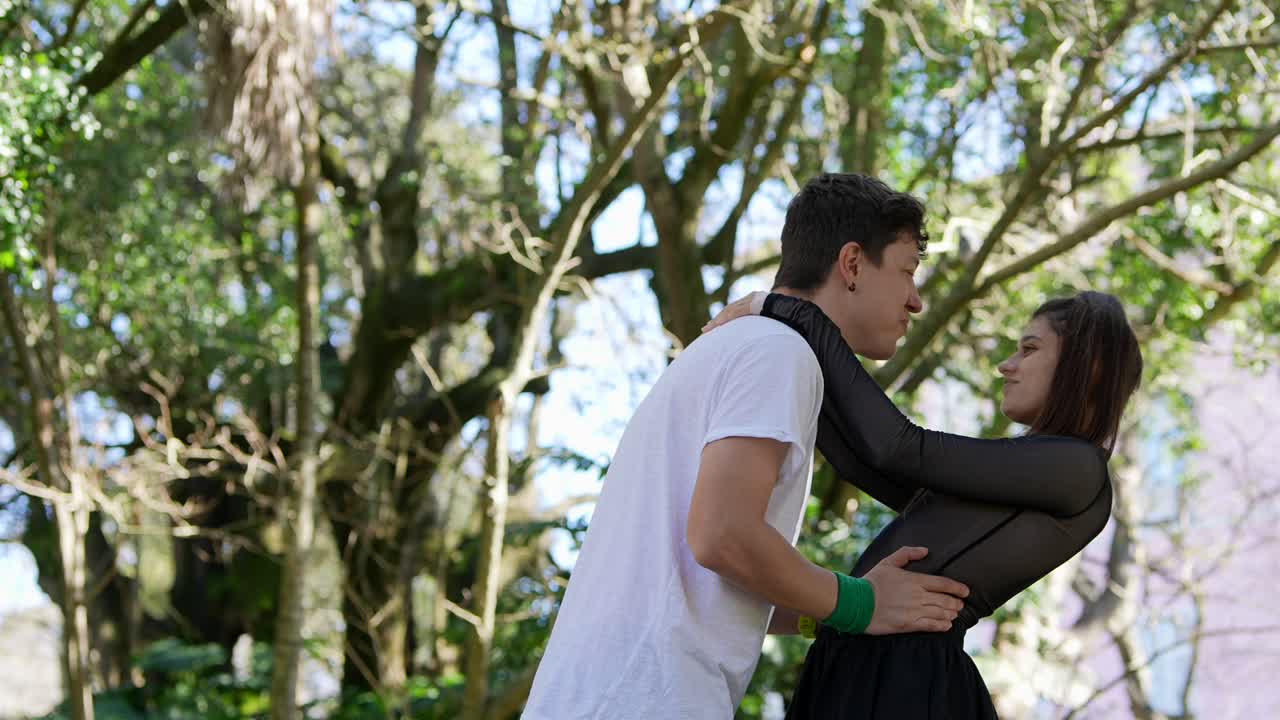 una pareja bailando en un parque.