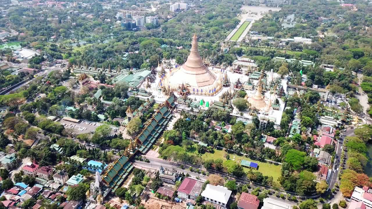미마 랑군의 울창한 초록색으로 둘러싸인 데곤 파고다 (shwedagon pagoda) 의 놀라운 공중 풍경, 도시의 중심에 있는 황금 첨탑과 복잡한 건축물을 보여줍니다.