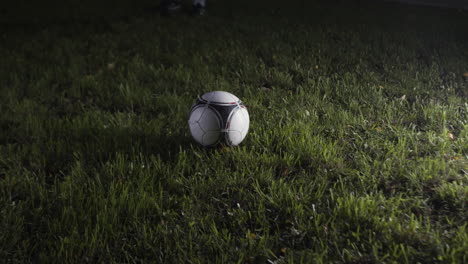 jugador de fútbol pateando la pelota por la noche