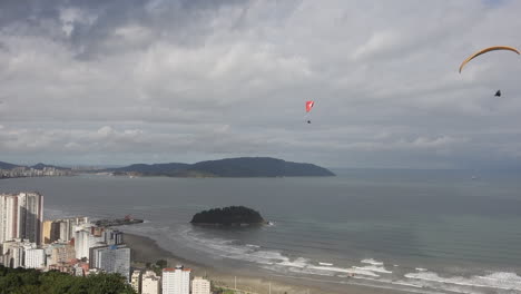 afternoon rain clouds roll in as paragliders float above santos brazil