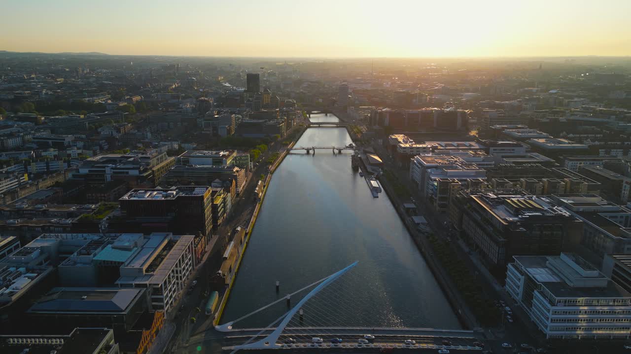 Aerial dolly reverse view of Liffey River in the heart of Dublin City during a golden sunset time in summer