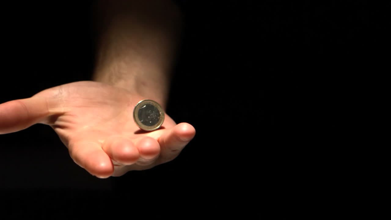 moneda siendo arrojada y atrapada