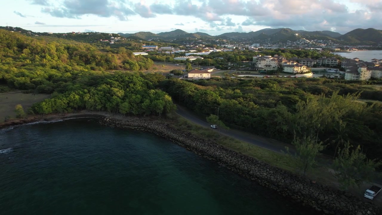 Una piccola jeep bianca che percorre una strada costiera a Saint Lucia