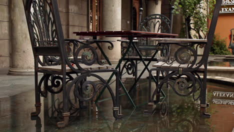 street cafe with metal tables and chairs on wet ground in batumi, georgia