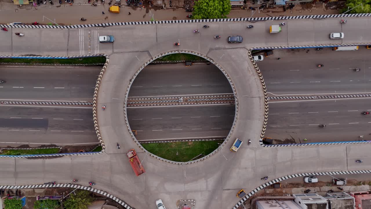 Top view of traffic circle intersection in flyover for navigating vehicles during daytime. Drone shot.