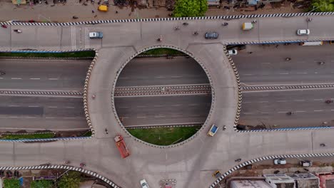 top view of traffic circle intersection in flyover for navigating vehicles during daytime. drone shot.