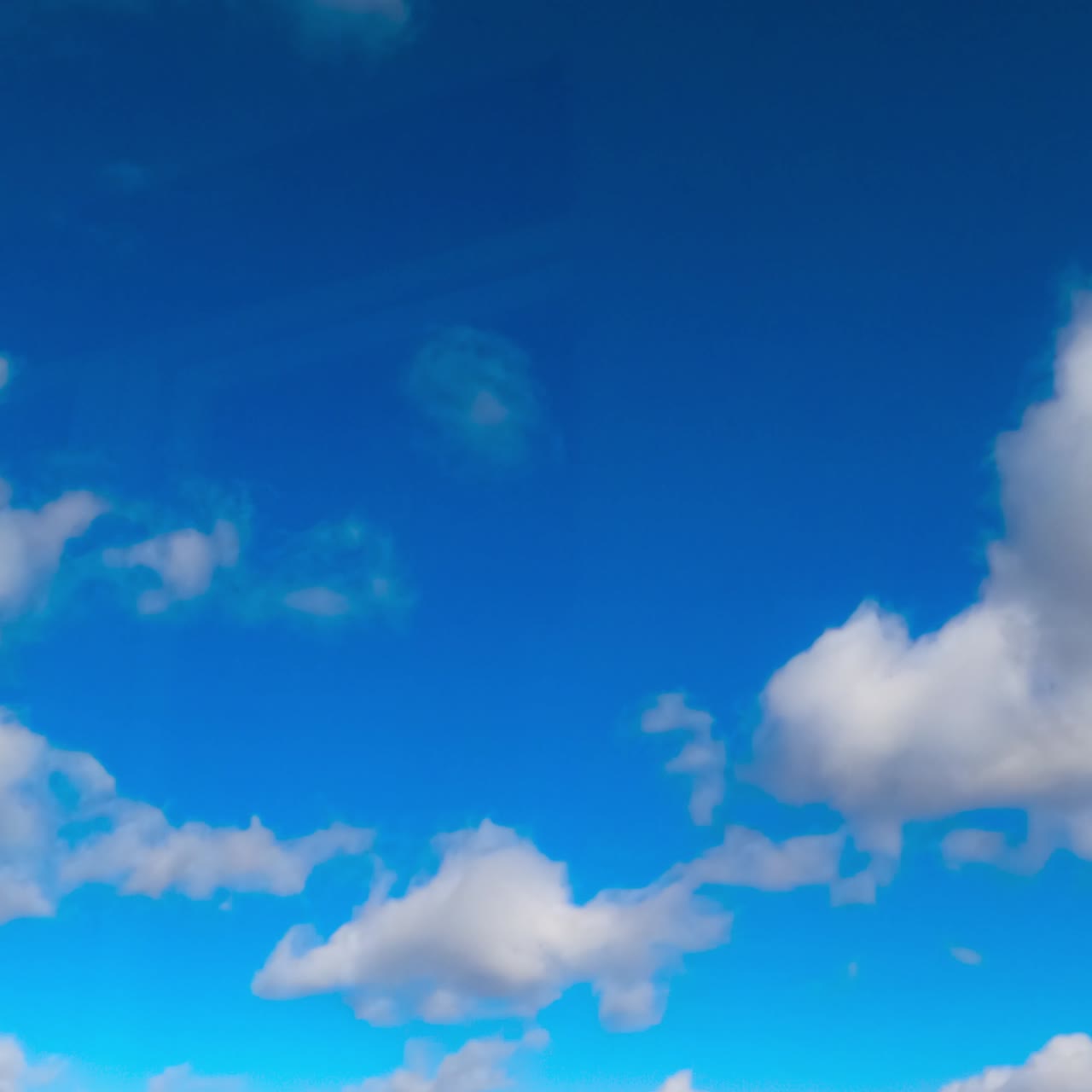 Fantastic azure sky with white clouds flying quickly by. Summer sky timelapse. Low angle view