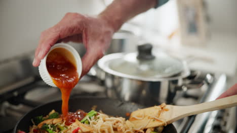 cooking stir fry with noodles and vegetables