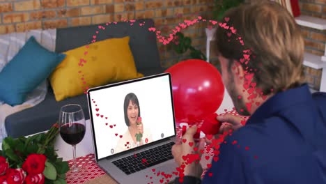 red heart outline against caucasian man showing a ring while having a video call on laptop