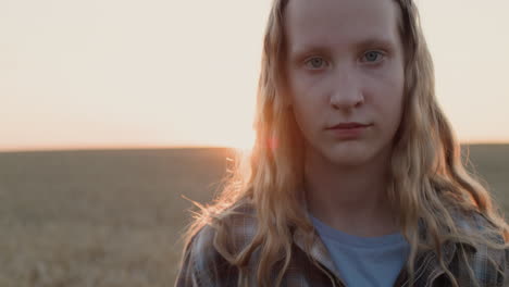 Portrait-of-a-cutev-teenage-girl-on-the-background-of-a-field-of-wheat-where-the-sun-sets