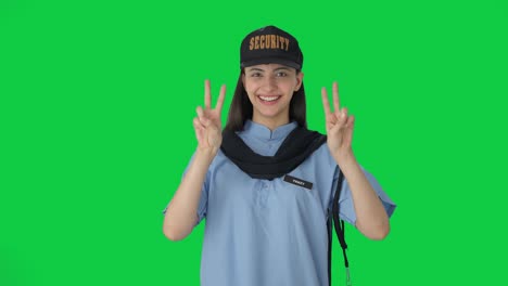 Happy-Indian-female-security-guard-showing-victory-sign-Green-screen