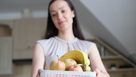 a beautiful woman of european appearance holds a basket of fruits in her hands a beautiful woman of european appearance holds a basket of fruits in her hands time in your own kitchen healthy and useful food
