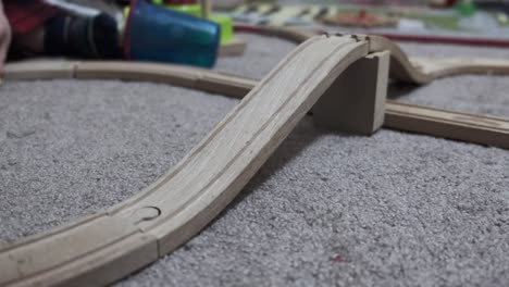 Close-up-low-angle-view-of-a-parent-and-child-playing-with-a-toy-train-set