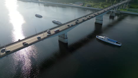 aerial view of a bridge with traffic over a river with boats