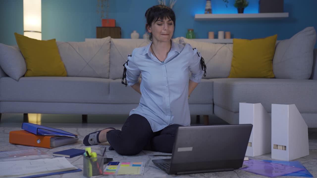 una mujer que trabaja en la oficina tiene dolor de espalda.