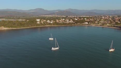 drone fly above three sail luxury boat in east coastline of sardinia island during golden hours