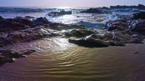 sun shining at a rocky coastline