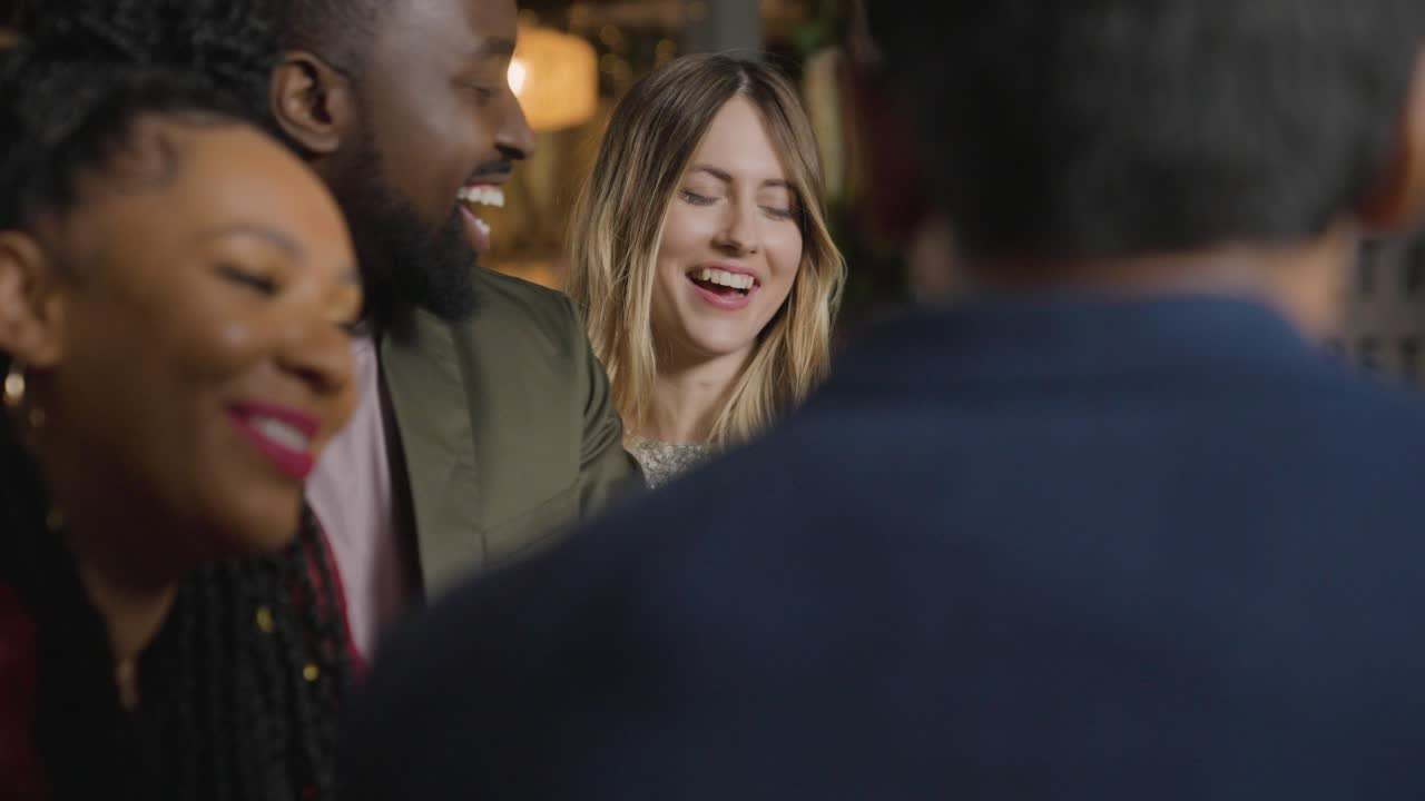 Tracking Shot of a Group of Friends Talking and Laughing In a Bar