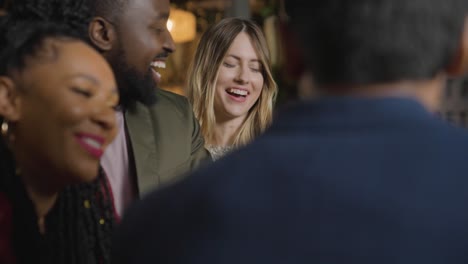 tracking shot of a group of friends talking and laughing in a bar