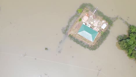 flooded village in bangladesh with submerged house in flood water. aerial top down shot
