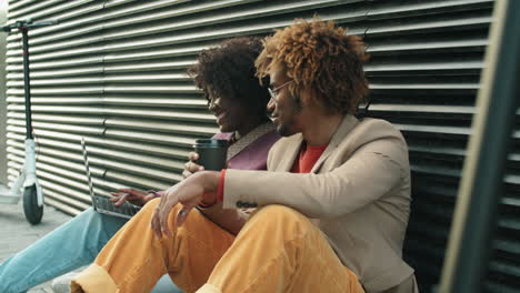 Hombre-Y-Mujer-Afroamericanos-Usando-Laptop-Y-Hablando-En-La-Calle