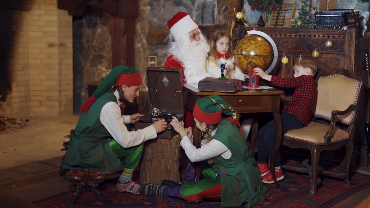 Santa looking at globe with child. Santa Claus showing little girl the globe in residental room