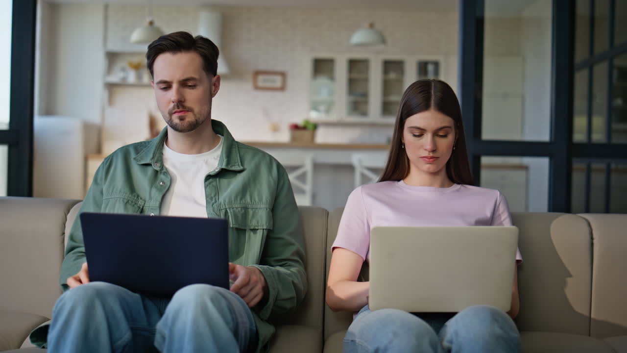 Freelancers couple using laptops work remotely domestic interior. Online job