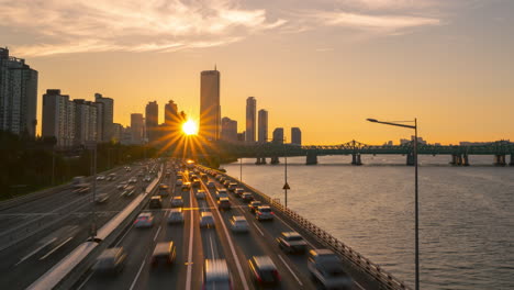 Sun-Setting-Over-Seoul-Yeouido-63-Building,-View-From-Hangang-Bridge-on-Cars-Traffic-on-Olympic-Expressway---elevated-view