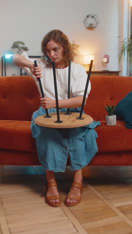 happy caucasian young woman finishing assembling furniture after moving into new apartment home