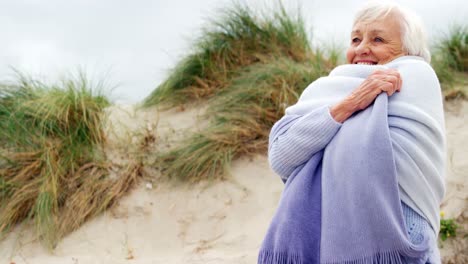 happy senior woman in sweater feeling cold