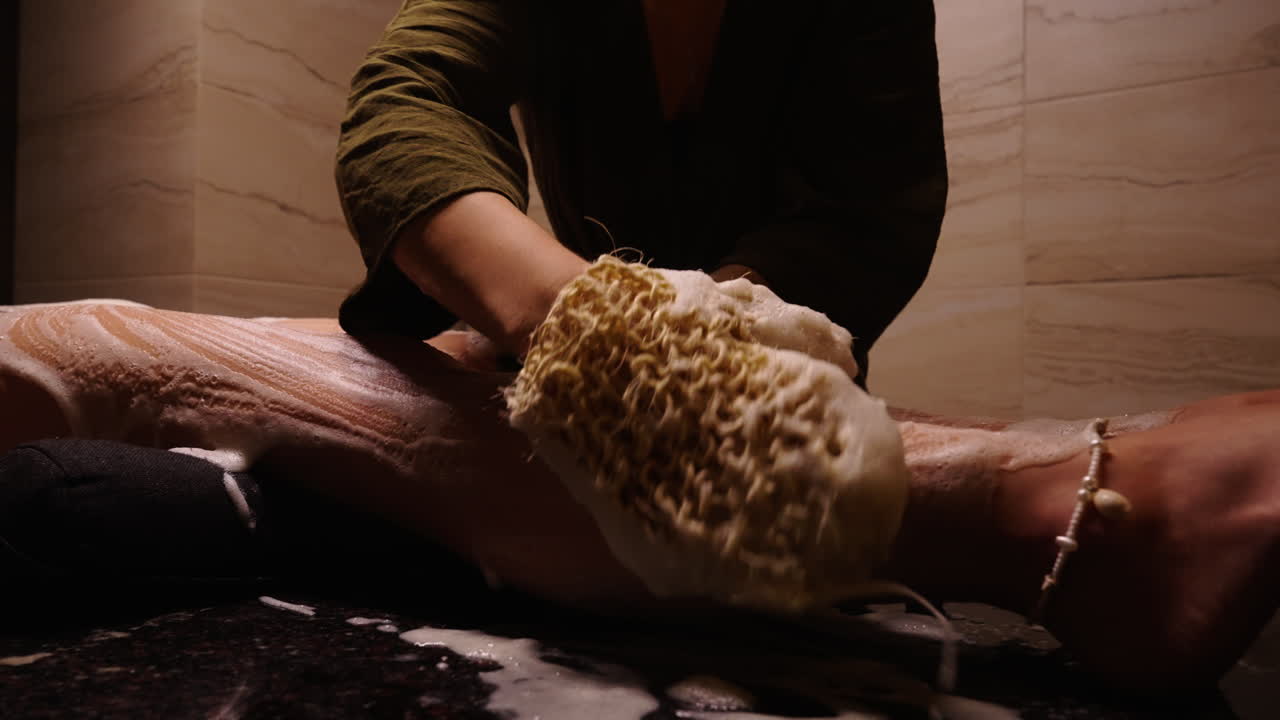 Woman getting a leg massage with a sponge