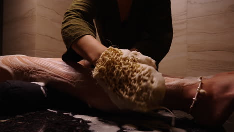 woman getting a leg massage with a sponge