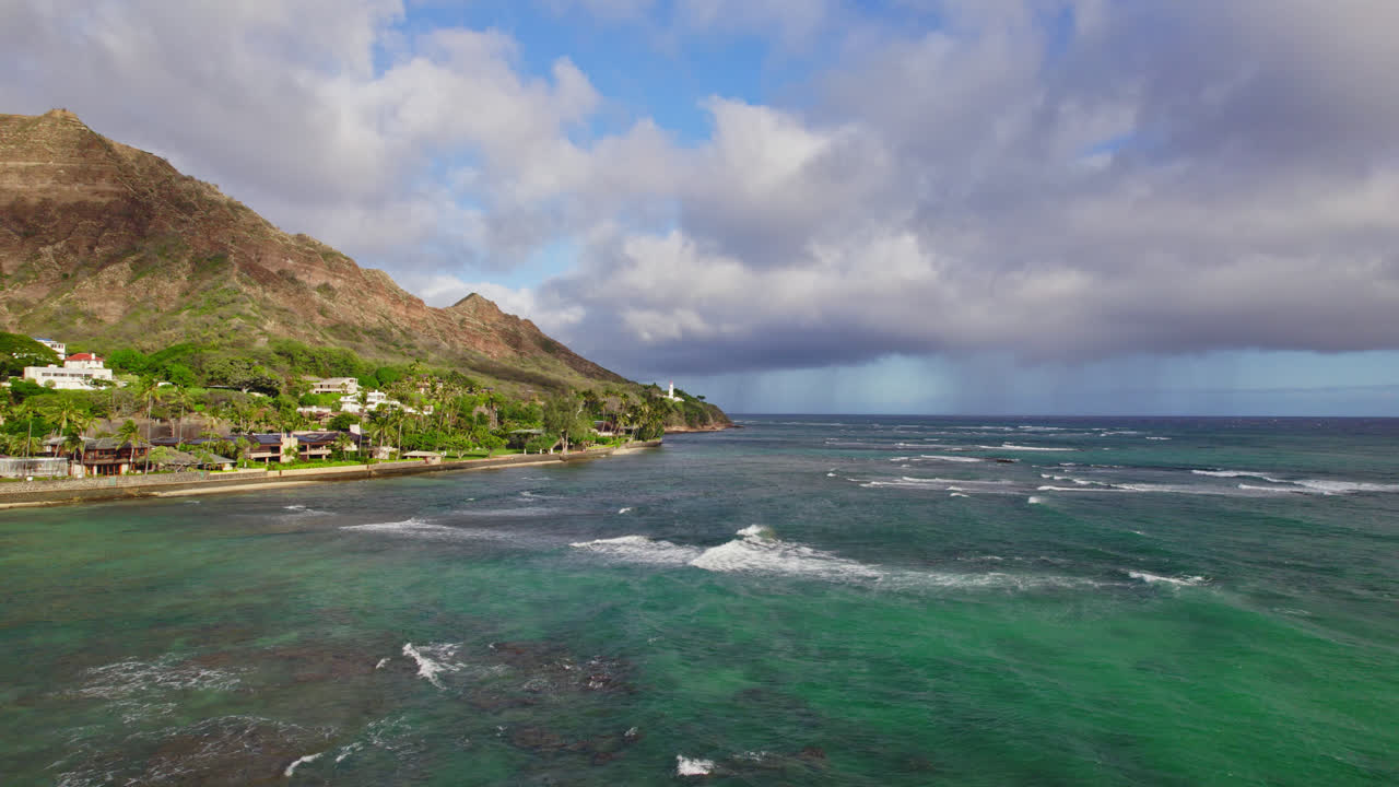 Montagne, mare e cielo si uniscono per formare un paradiso a Diamond Head, Hawaii, con acqua turchese, cielo blu e formazioni montuose vulcaniche.