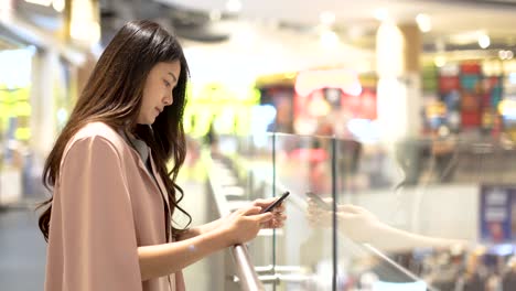 asian women playing cell phones in shopping malls.