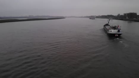 Container-ships-sailing-down-river-on-overcast-day