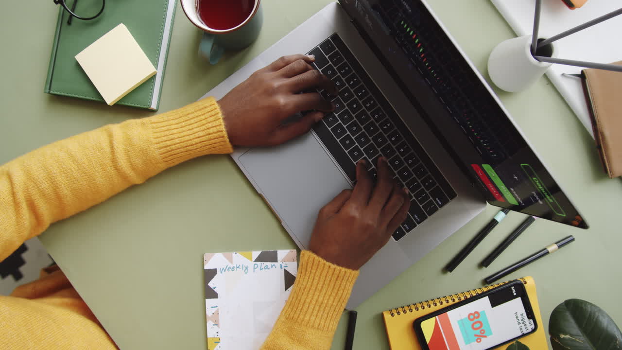 persona que trabaja en un escritorio con portátil y teléfono móvil